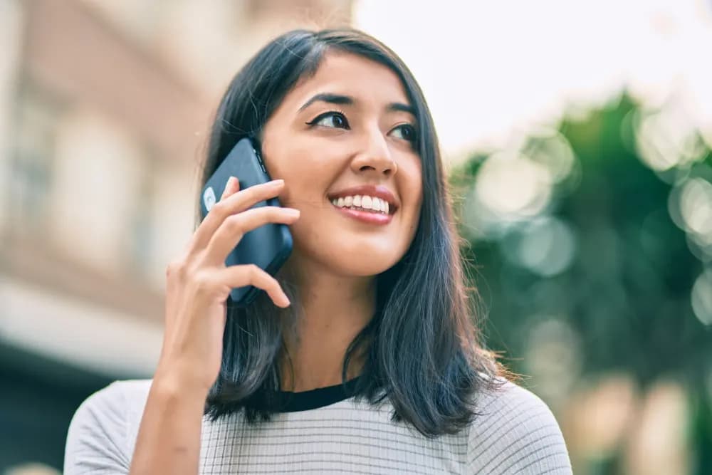 Woman smiling on the phone in the street