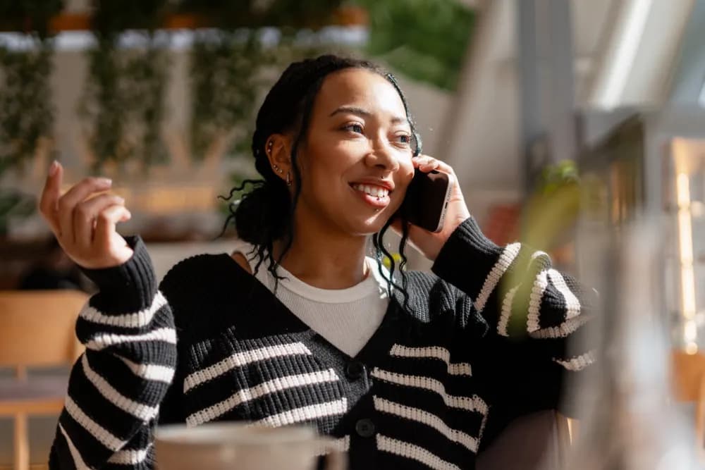 Customer smiling on the phone in a café