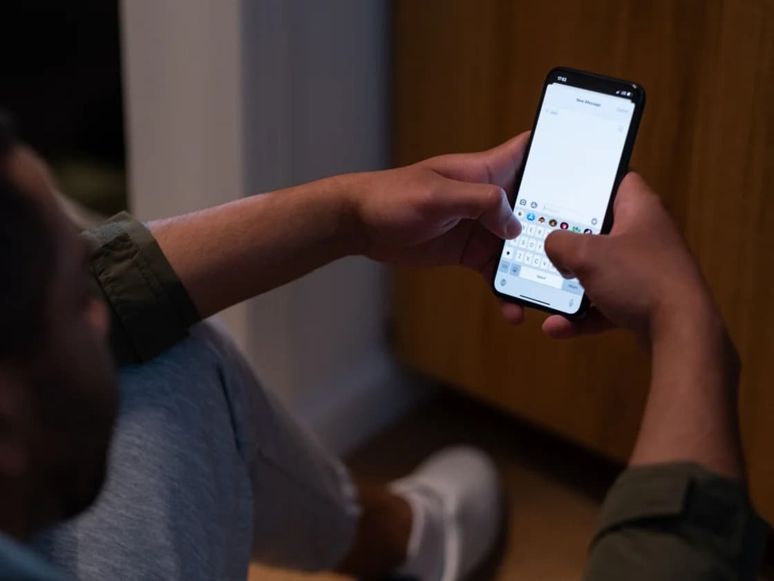 Personne écrivant un message sur son téléphone, le soir